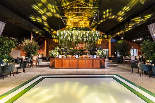 Home Spacious event venue with elegant floral arrangements and modern decor, perfect for celebrations.